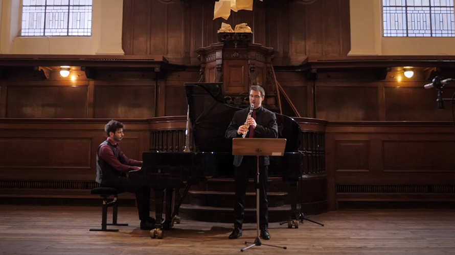 classical duo performing in a church in front of the organ for a live recording