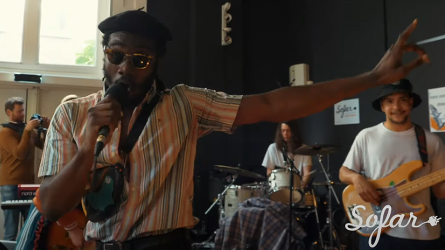 man with a microphone from the funk party band performing at the house concert 